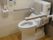 背もたれと手すり付きのトイレには呼び出しボタンが設置され、可動式のバーもある。