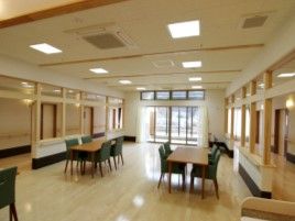 グリーンの椅子とベージュの机の組み合わせが複数ある広い空間