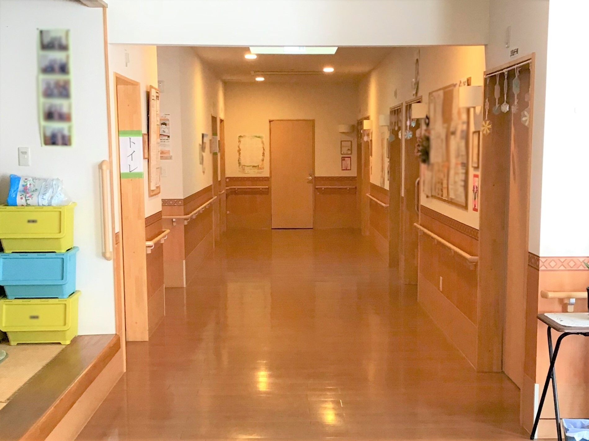 居室は入居者様の名前ではなく、植物の名前で分けられている。非常口の指示看板が掲示されている。奥には受付がある。