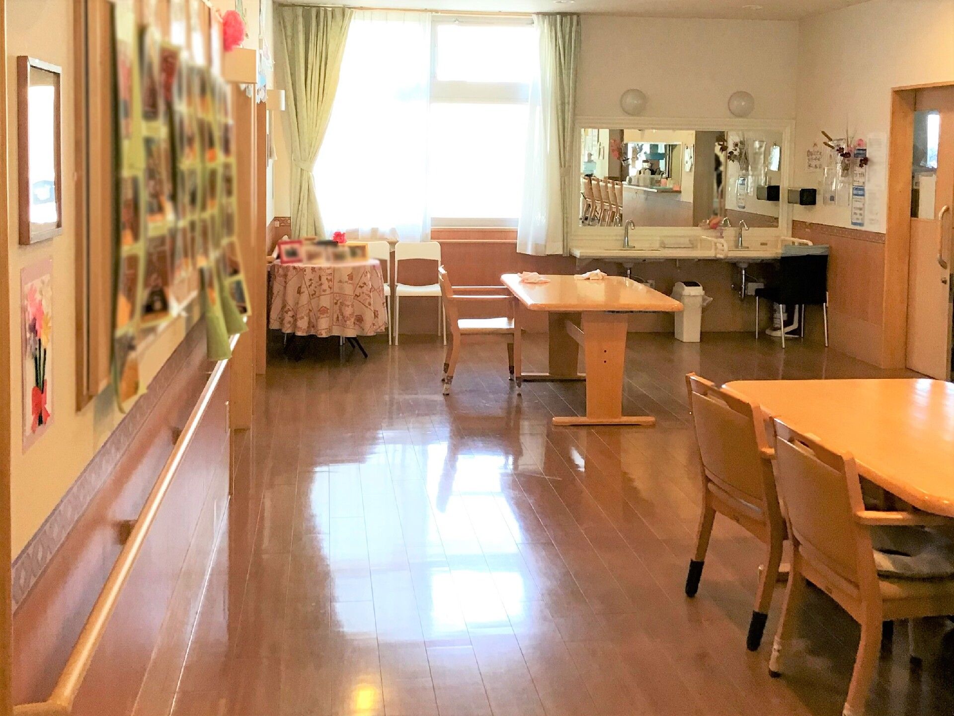 日当たりが良く広々としたリビングダイニングでは、入居者様が集まって食事やレクリエーションを楽しんでいる。
