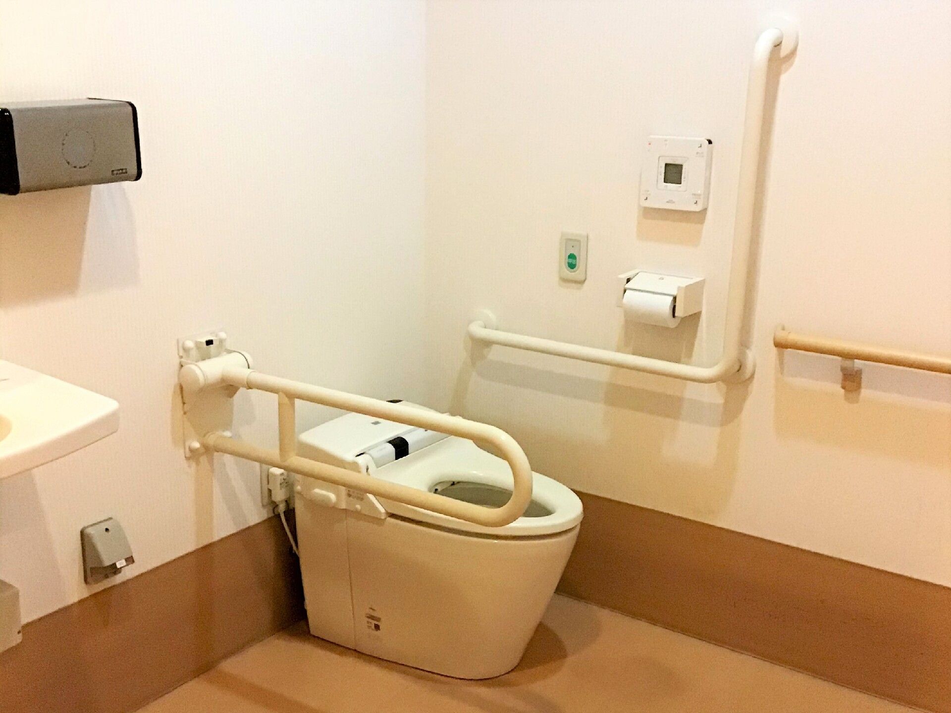 手すりと呼出ブザーがあり、手洗いボウル、手すりが付けられた温水洗浄便座が採用されたトイレ