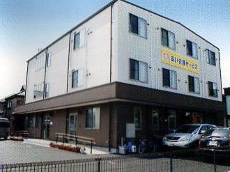 鉄骨造３階建ての建物の様子。駐車場があるのが分かる