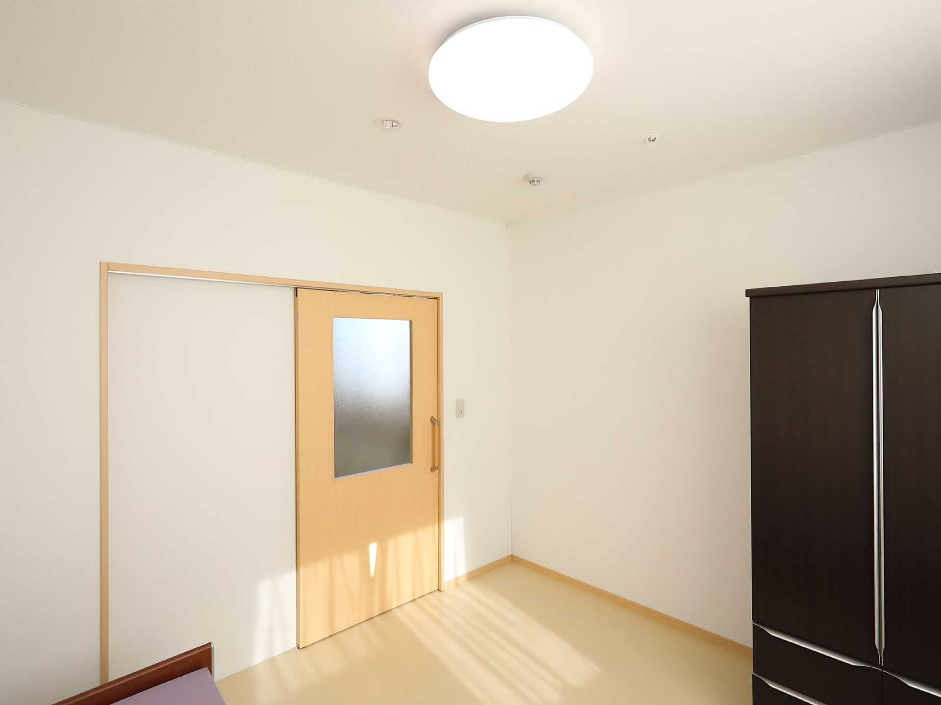 居室には、ベッドと収納タンスが備えつけとなっている。トイレなどの水まわりは共用のものを使うようになっている。