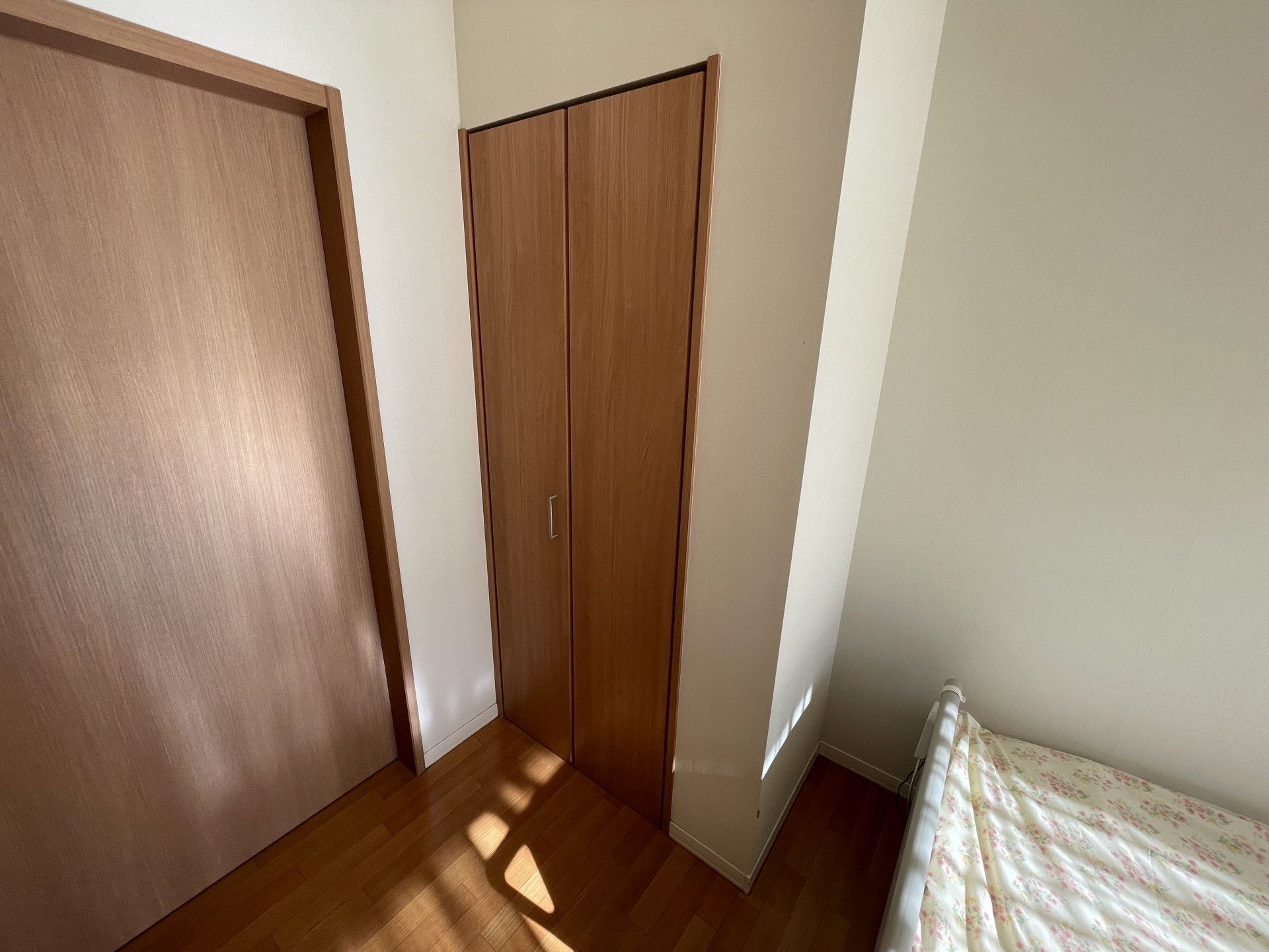 木製の扉とベッドの部屋