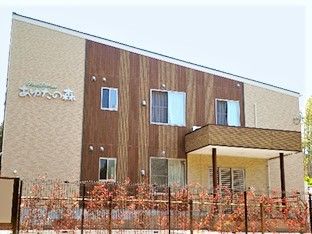 ツートンカラーの建物の外観写真。雨除けがついたモダンなデザインの建物