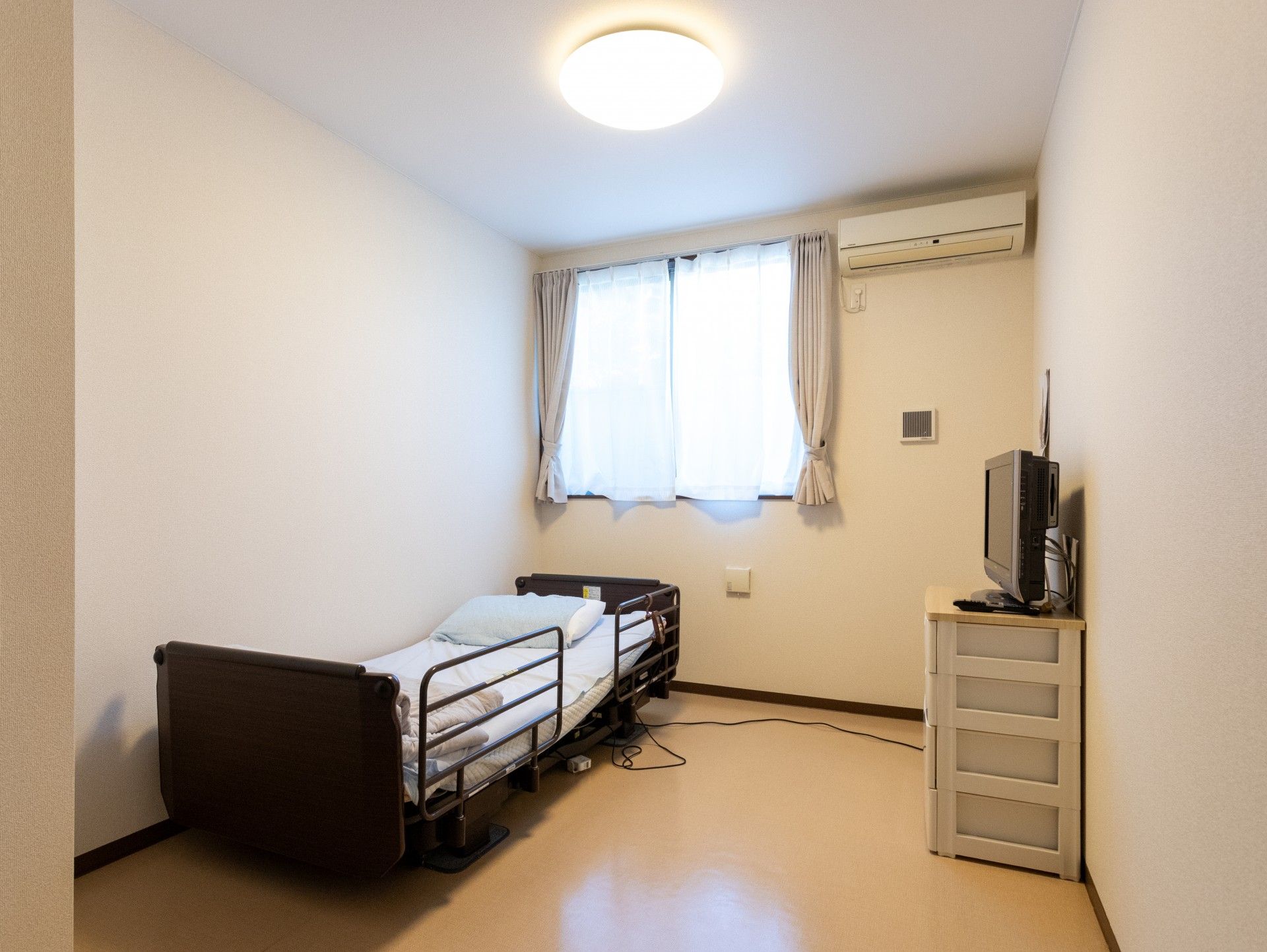 介護車両の前で顔を見合わせる車椅子に乗った高齢女性と女性ヘルパー