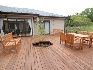 平屋建ての建物と外側の大きなウッドデッキ。施設内のリラックススペース