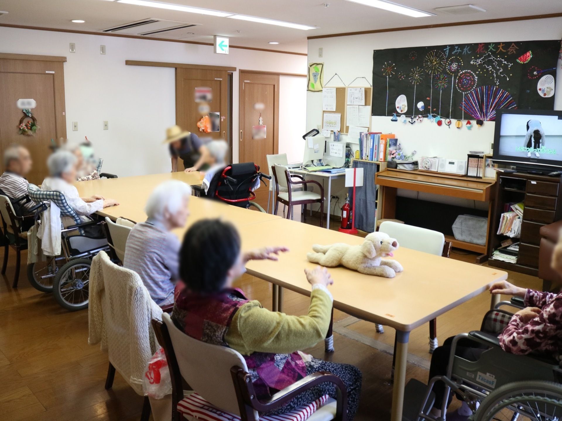 入居者様はテーブルを並べたところに、集まっている。そして多くが目の前にあるテレビを観て、過ごされている。