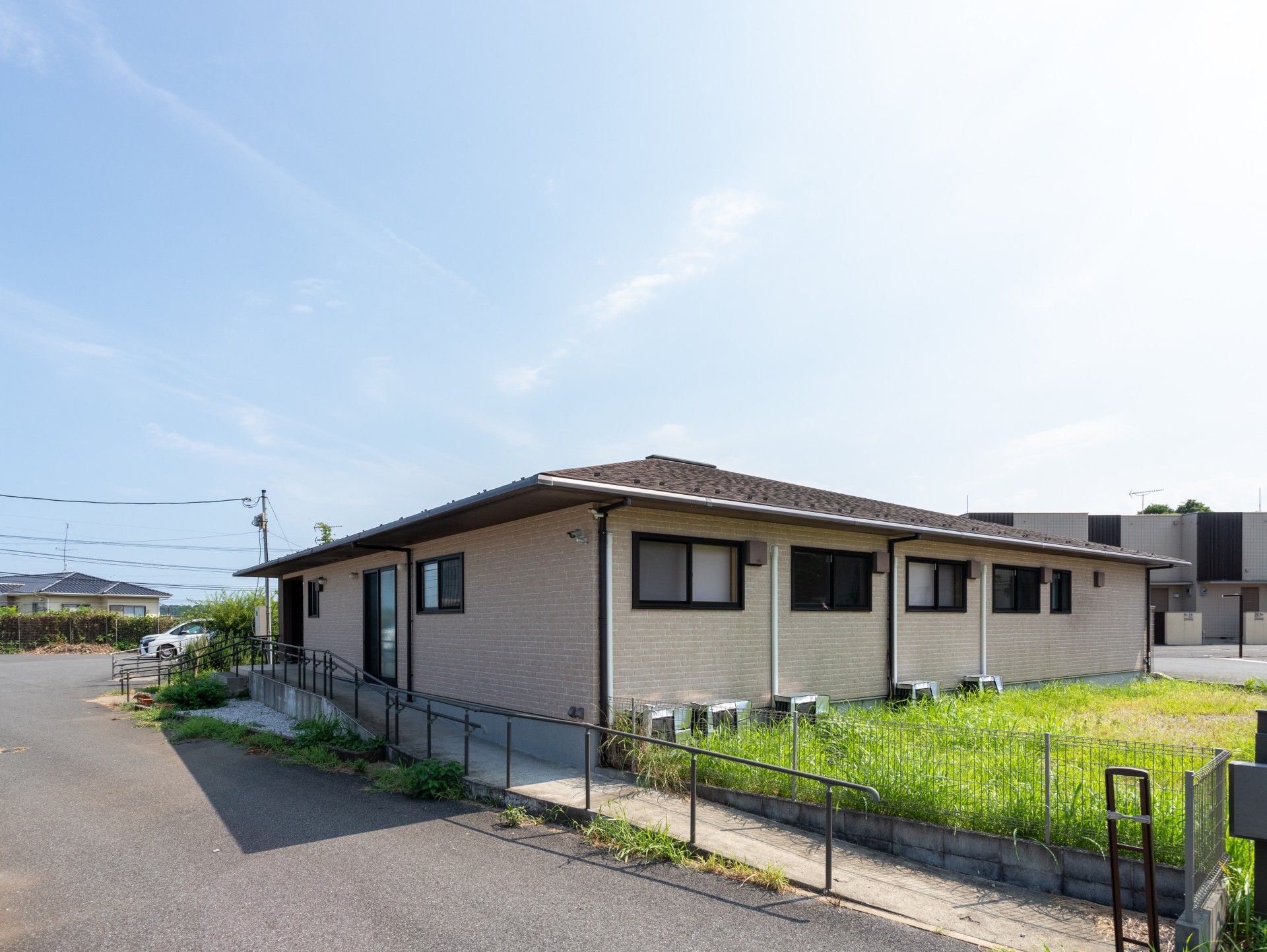 笑顔で屋外で何かを鑑賞している車いすの高齢女性と高齢男性、付き添いの男女のスタッフ。