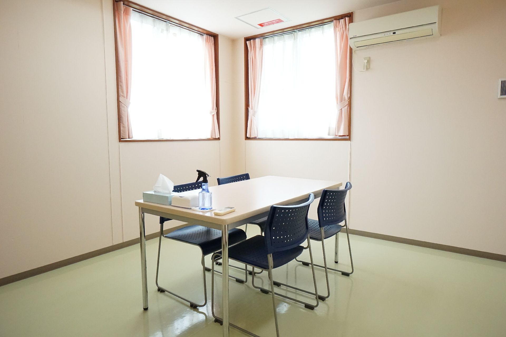 なにかを指さして笑顔で話している車いすの女性とそれを押している介護スタッフの様子