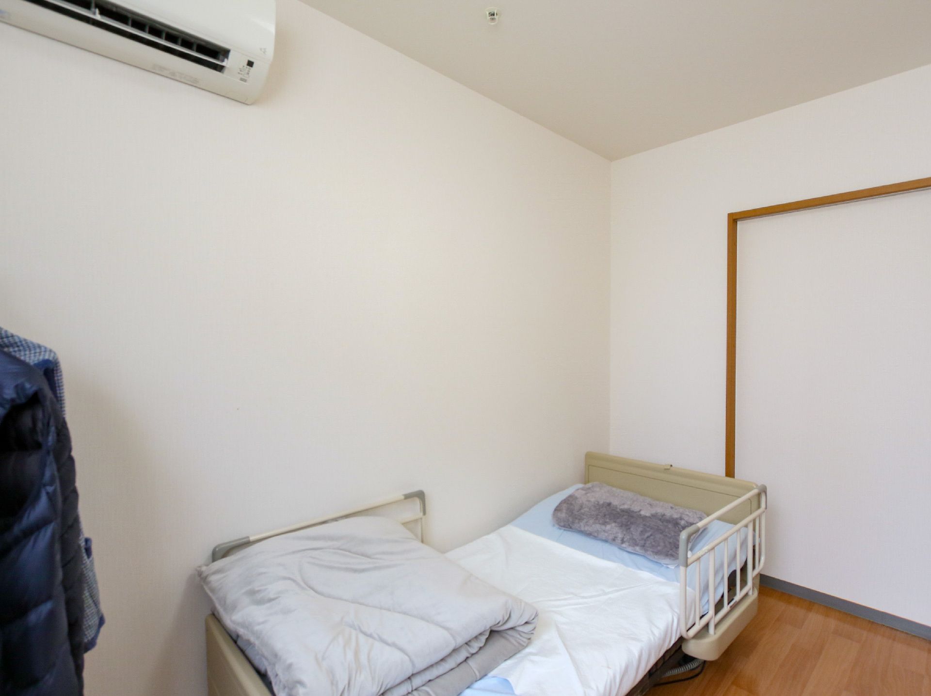 介護ベッドが置かれ、引き戸のドアが設置されている居室