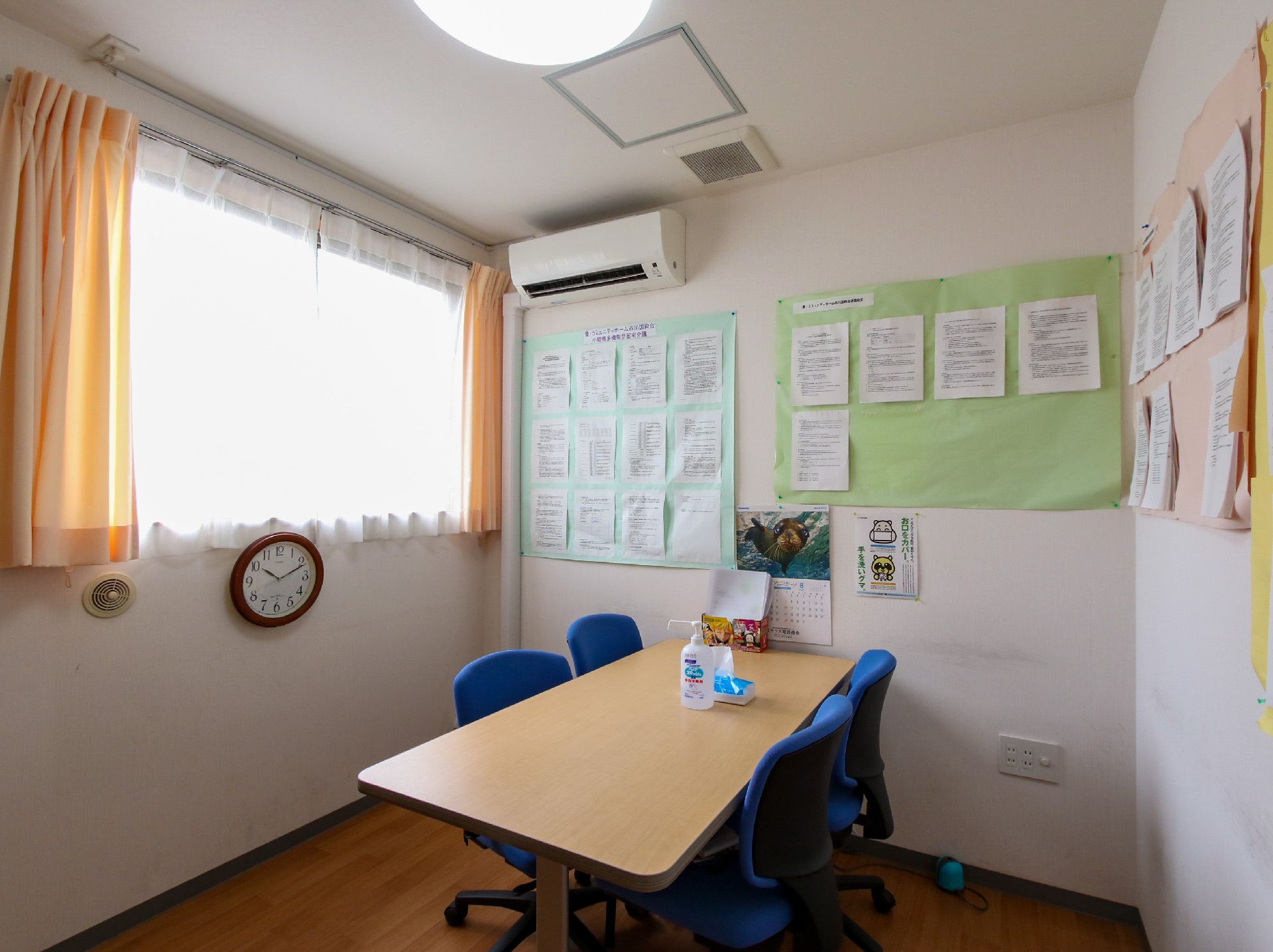 介護車両へ移動する車椅子に乗った高齢女性と介助をする女性ヘルパー