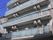 5階建ての建物は各フロアにベランダが付き、グレーでまとめられている。