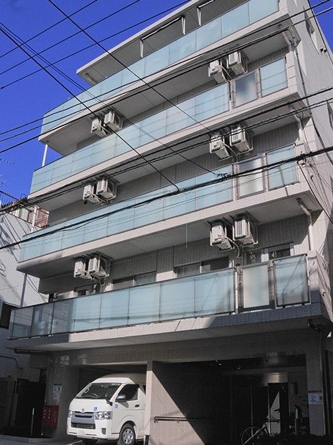 5階建ての建物にはベランダが付き、1階部分には駐車場がある。