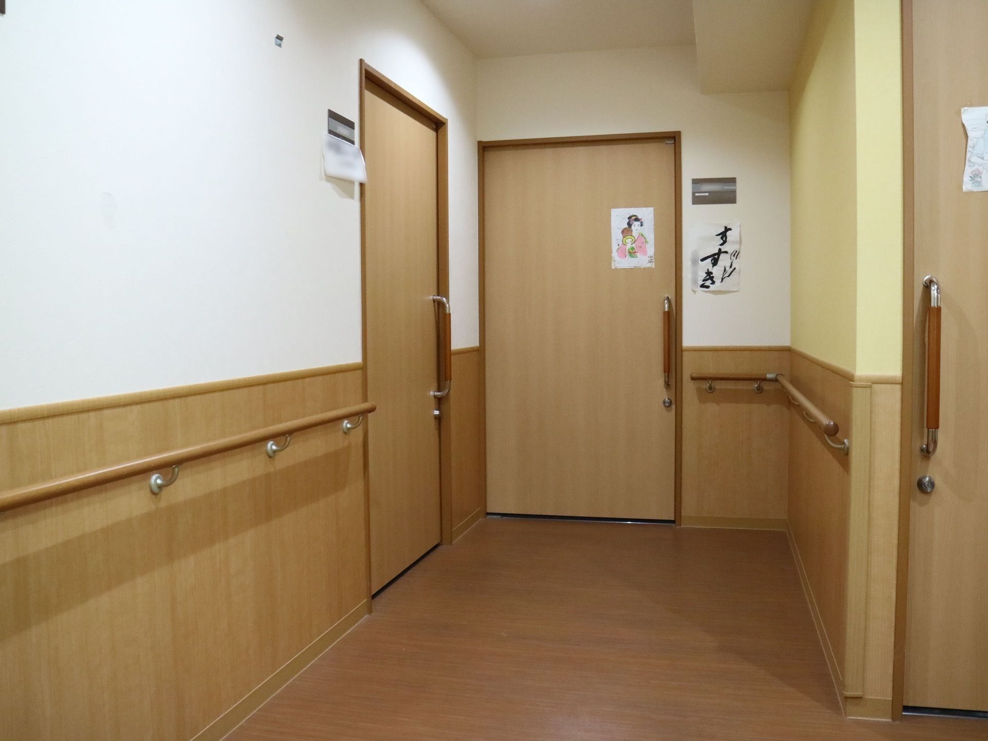 居室までの通路には手すりが続いている。段差のないフラットな引き戸なので、車椅子をご利用の方にも使いやすい。
