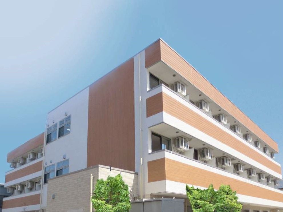 白とベージュのツートンカラーの建物の写真。清潔感のあるデザインが印象的な建物