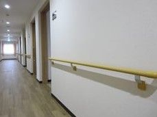 白い壁には木製の手すりが付き、廊下の突き当りには大きな窓があり、明るい。
