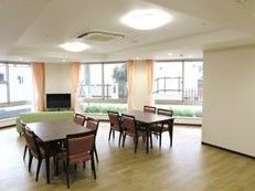 大きな窓が付いた明るい共有スペースにはダイニングテーブルやソファ、大きなテレビが付いている。