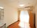大きな窓から陽の光が差し込む明るい部屋である。部屋には、エアコンやタンス、洗面台などが設置されている。