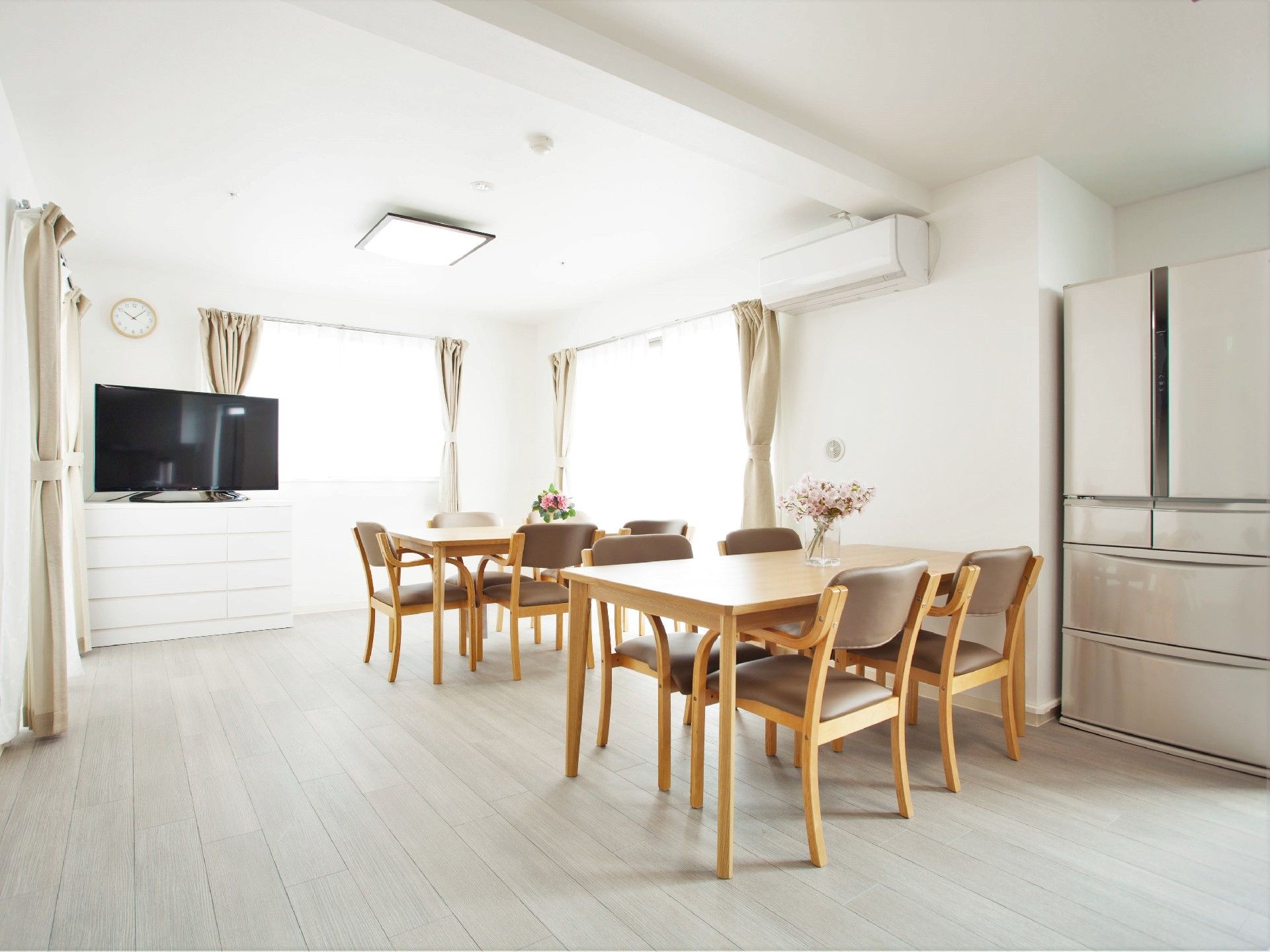 4人掛けのテーブルが二組設置された食堂には大きな冷蔵庫やテレビがあり、明るい雰囲気。