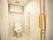 トイレは引き戸で広く、トイレットペーパーホルダーの上にはアイ型の手すりが設置されている。