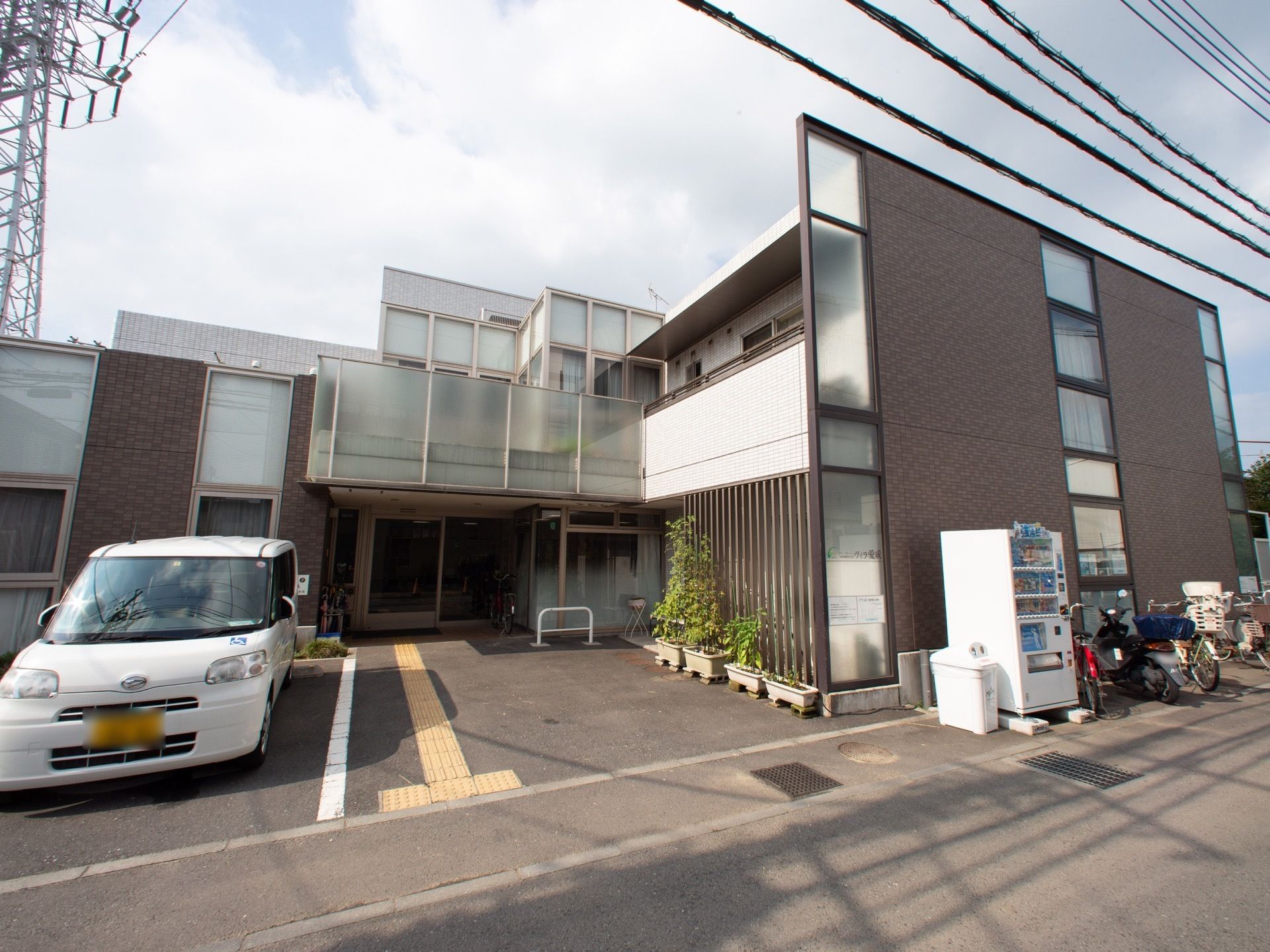 施設を出た場所に自動販売機を設置し、飲み物を手軽に購入することができる。こげ茶色のレンガ風の外装はモダンな雰囲気である。
