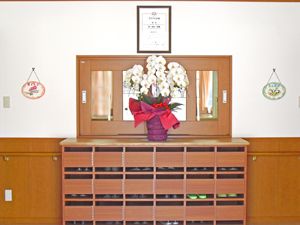 げた箱を正面から写した写真。花や絵が飾られている壁を写したもの