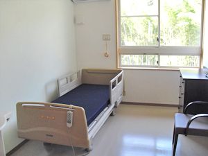 一人用のベッドと椅子が置いてある小さなワンルーム。施設内の居室の様子
