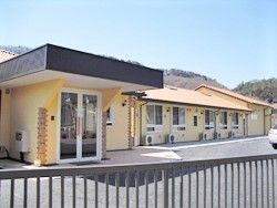 駐車場スペースが手前にあるグループホーム夢かごの外観写真。平屋建ての建物の様子