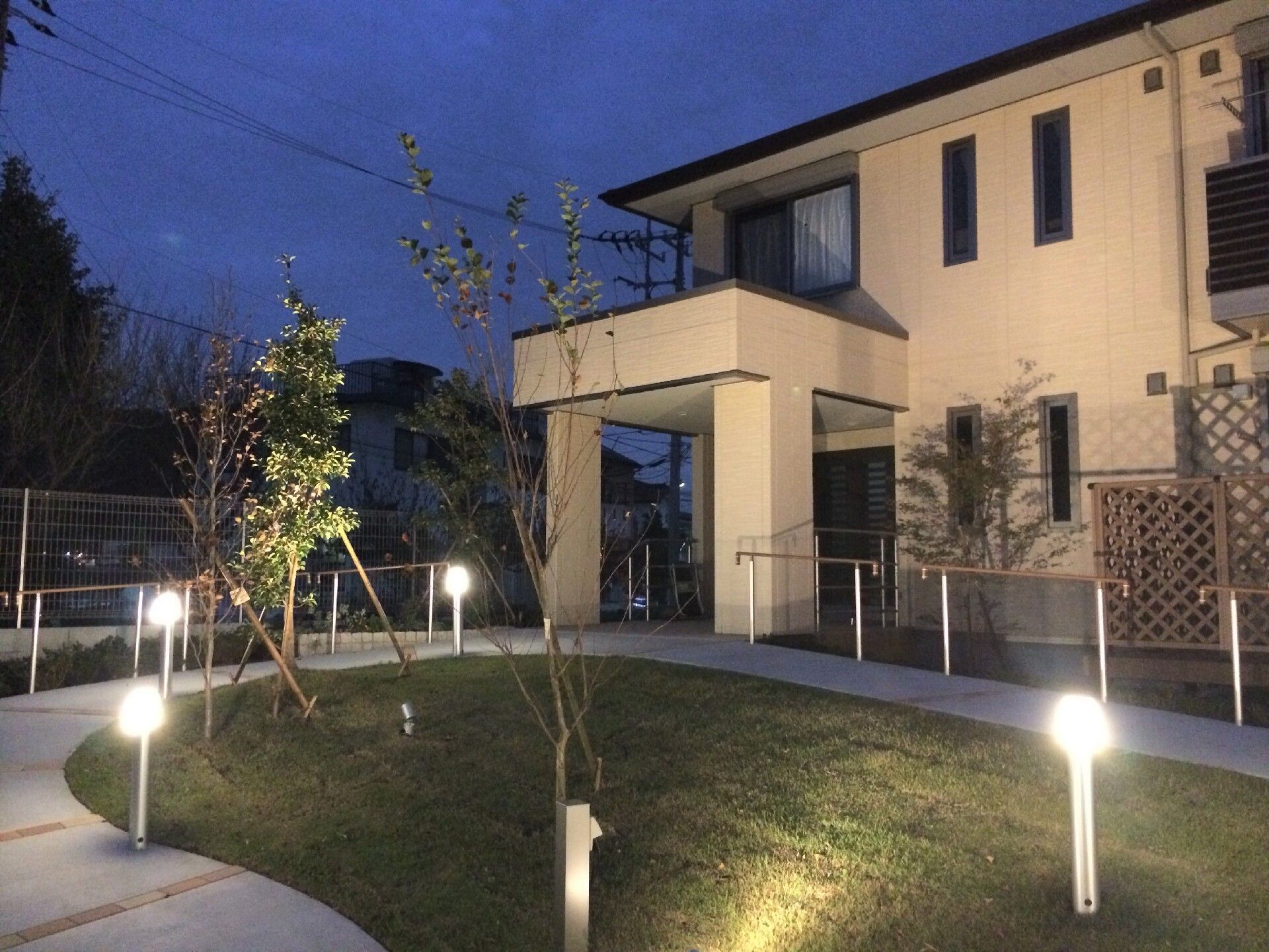 中庭にあるライトで照らされた高齢者向け住まいの外観写真