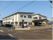 屋根が付いた2階建ての建物は日当たりのいい場所に建っていて、敷地内には駐車スペースもある。