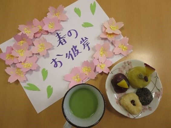 「春のお彼岸」と書かれた紙のそばには抹茶と４種類のおはぎが盛られた皿が置かれている。