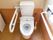 清潔感のある白色の洋式トイレが設置されている。壁と床は木目が使われており、落ち着いた雰囲気になっている。