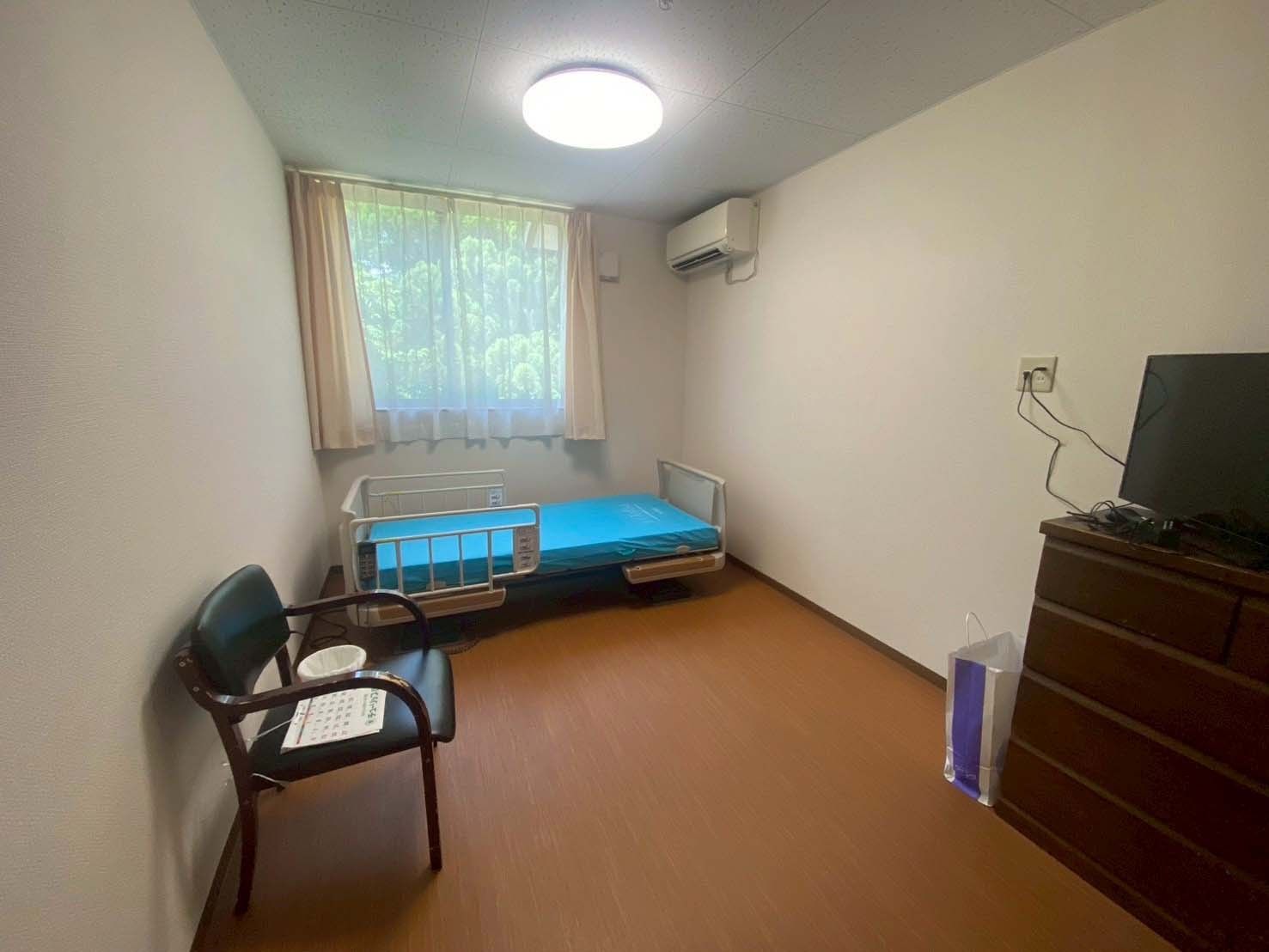 車椅子に乗った高齢の男女を介助するヘルパー