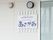 外壁には施設名が記された看板が設置されており、通路から目立ちすい。看板には朝顔のデザインが描かれている。