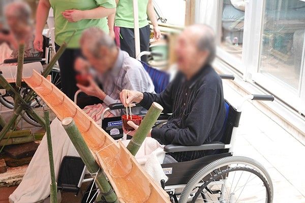 車椅子で流しそうめんを楽しむ様子