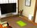 居間には畳が敷かれ、大きな机や木製の座椅子が並べられている。部屋の奥には、テレビが1台置かれている。
