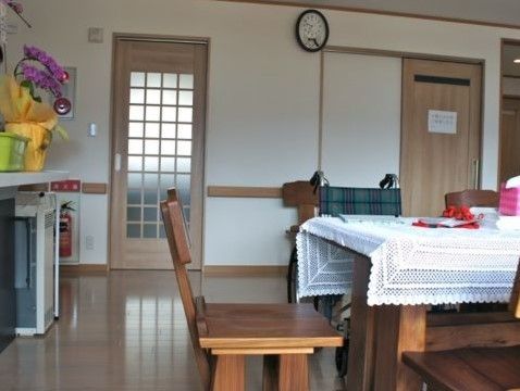 小さなリビングの様子。時計、木製のテーブル、いすなど