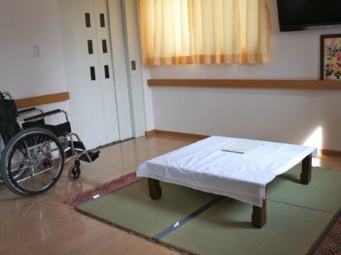 車いすと畳敷きがある部屋の様子。窓から日差しが差し込んでいる様子が分かる