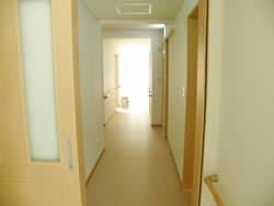 まっすぐな廊下は明るく、両サイドに居室のドアが並んでいる。手すりを設置し安全な造りとなっている。