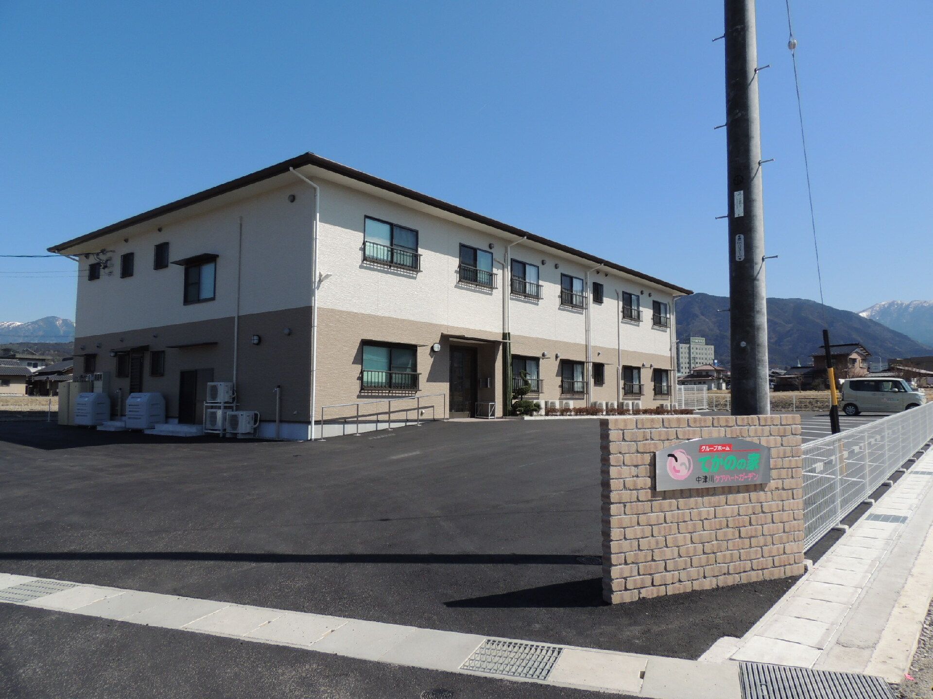 2階建ての建物は横に長く、ベージュでまとめられ落ち着いた雰囲気。