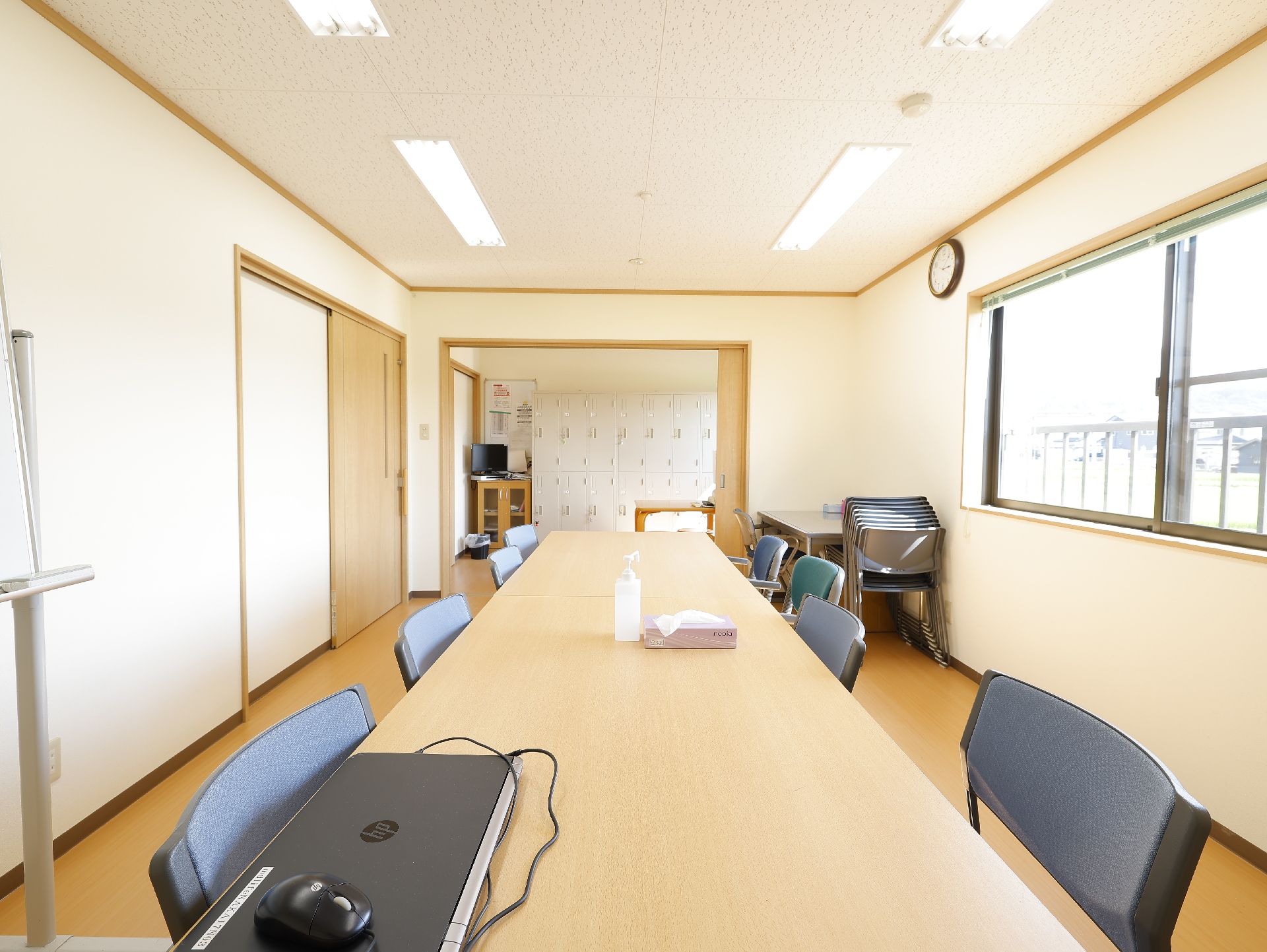 テーブルを挟んで椅子が設置され、パソコンが置かれているスタッフルーム