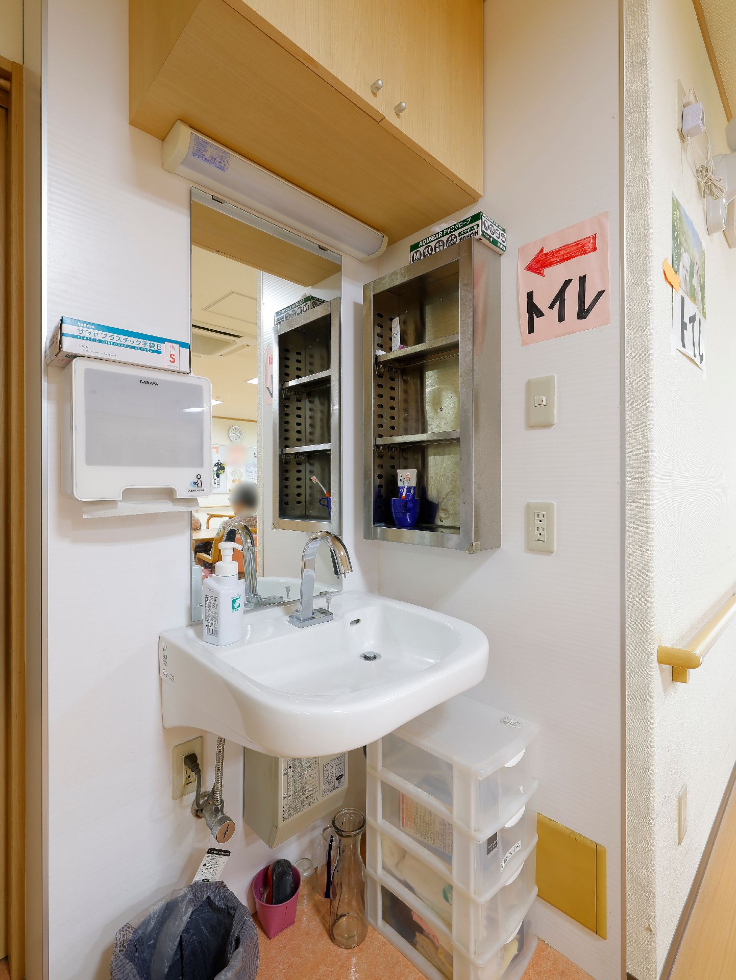 手洗い用の液体せっけんや入居者の歯ブラシなどが置かれている洗面台