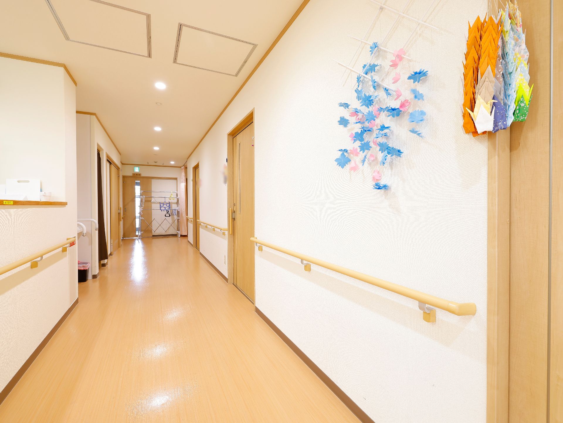 バリアフリー化されて段差がなく、壁に飾り物が展示されている廊下
