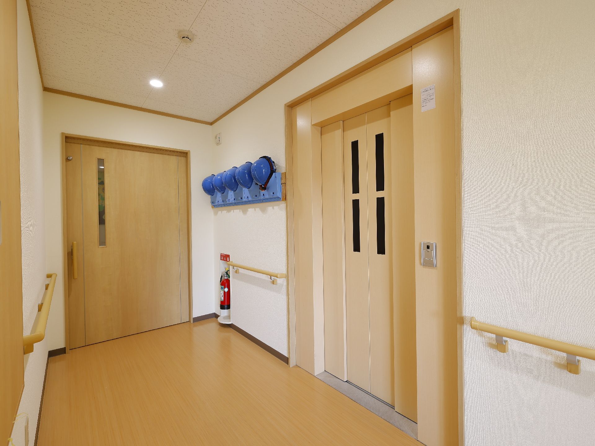 出入口までの廊下に手すりが設置され、安全にアクセスできるエレベーター