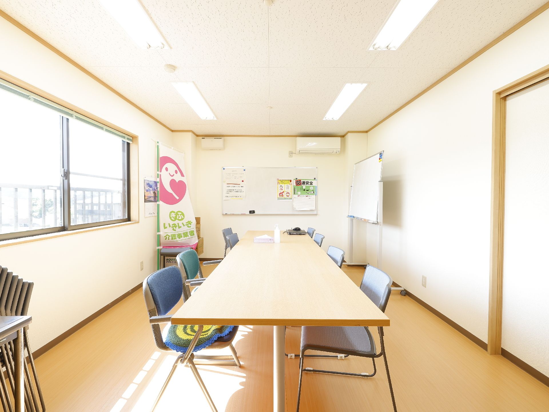 車椅子に乗った高齢女性と寄り添う女性ヘルパー