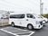 路面がアスファルトで舗装された駐車場があり、車が数台停まっている。側面に施設名が書かれた車が１台ある。
