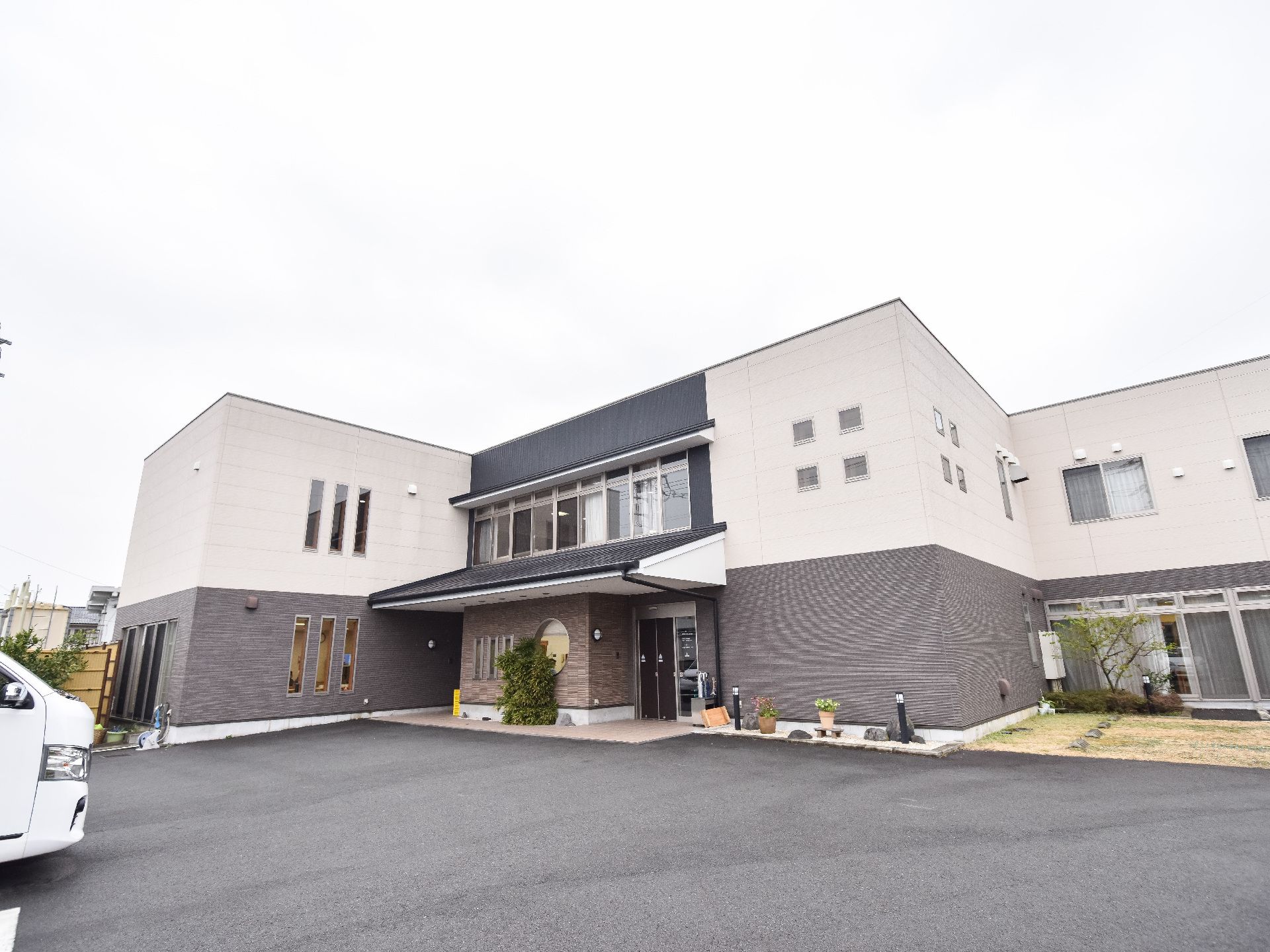 2階建ての建物は横に長く、駐車場も完備。建物の周辺には緑が多くある環境。