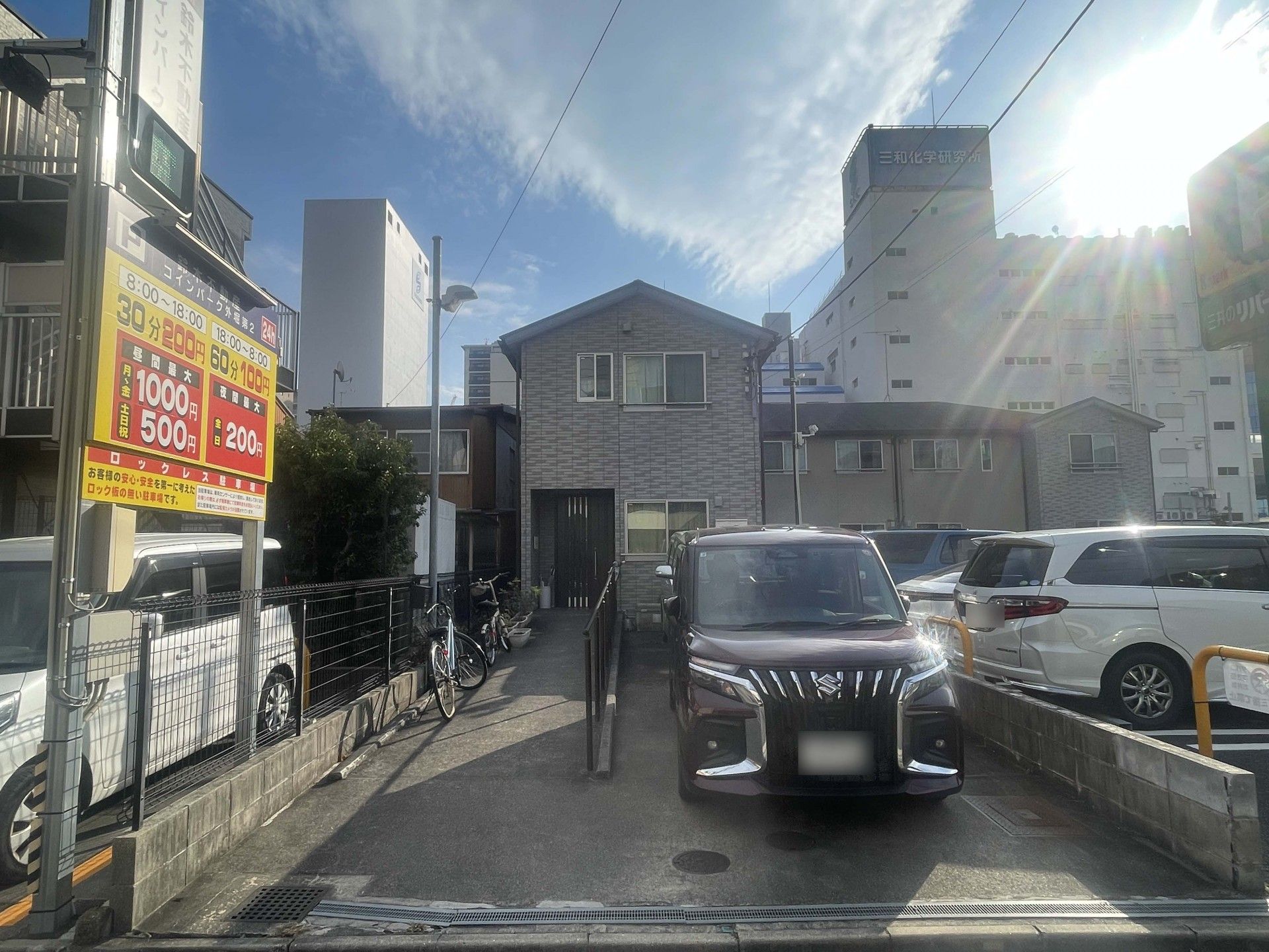 介護車両の前にいる車椅子に乗った高齢の男女とヘルパー