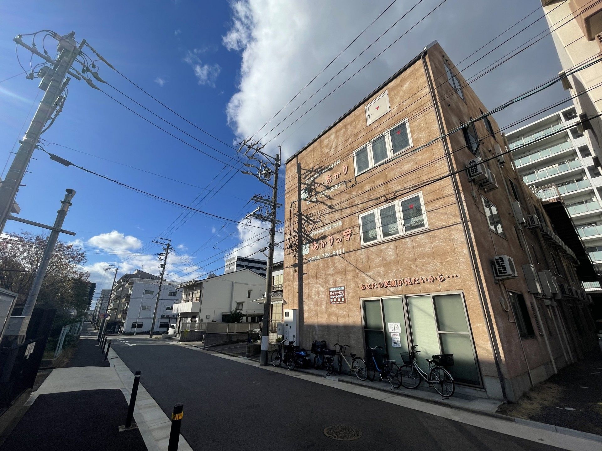 車いすに乗った女性を押す家族の男性とそこに寄り添う介護スタッフの様子